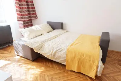 a bedroom with a bed with a yellow blanket on it at Budislav lovely apartment in Belgrade