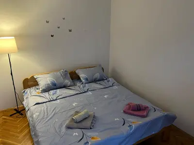 a bedroom with a bed with blue sheets and pillows at GOLD Apartman in Mirijevo
