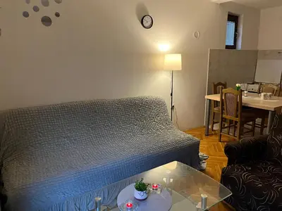 a living room with a bed and a table at GOLD Apartman in Mirijevo