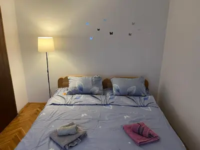 a bedroom with a bed with two towels on it at GOLD Apartman in Mirijevo