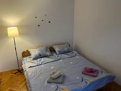 a bedroom with a bed with towels on it at GOLD Apartman in Mirijevo
