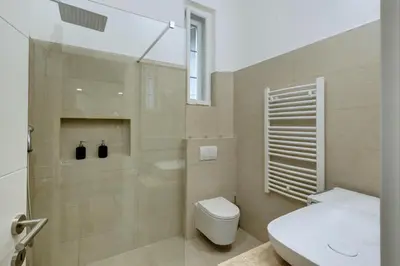 a bathroom with a toilet and a glass shower at Sunflower Apartment in Belgrade