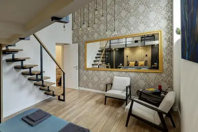 a living room with a staircase and a chair at Sunflower Apartment in Belgrade