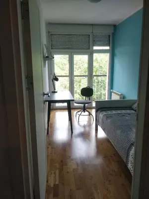a room with a bed and a table and a window at TikTok in Voždovac