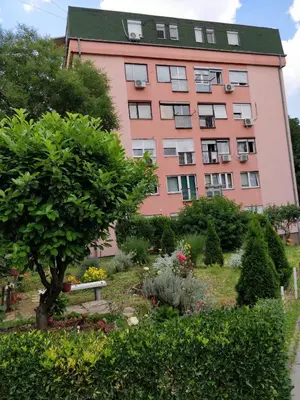 a pink building with a garden in front of it at TikTok in Voždovac