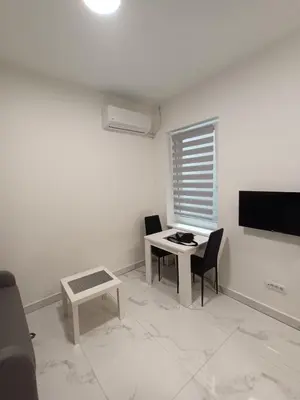 a living room with a table and chairs and a television at Gorana 1 in Belgrade