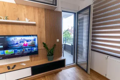 a living room with a flat screen tv on a wall at Apartman Kolarević in Arandjelovac