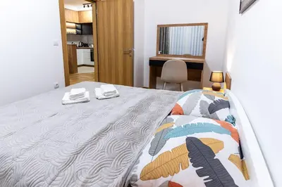 a bedroom with a bed and a desk in a room at Apartman Kolarević in Arandjelovac