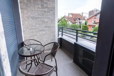 a balcony with two chairs and a table on a balcony at Apartman Kolarević in Arandjelovac