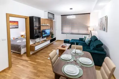 a living room with a dining table and a couch at Apartman Kolarević in Arandjelovac