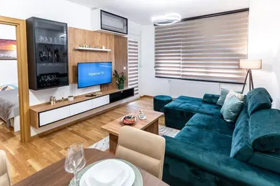 a living room with a blue couch and a tv at Apartman Kolarević in Arandjelovac