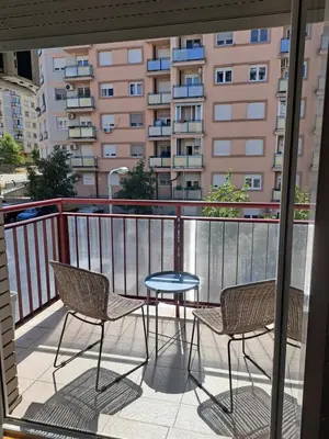 a balcony with two chairs and a table and a building at Belgrade Stepa Stay in Belgrade