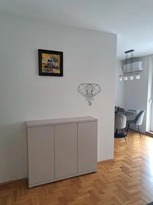 a living room with a white wall and a table at Belgrade Stepa Stay in Belgrade