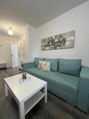 a living room with a blue couch and a table at BeoAir apartments in Surčin