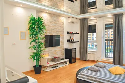 a living room with a bed and a tv at Hedonist Spa-ABlok 1 in Belgrade
