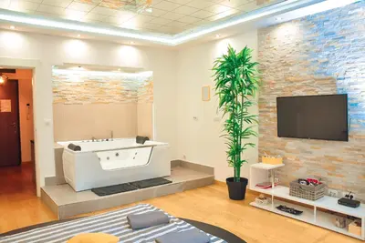 a living room with a bath tub and a tv at Hedonist Spa-ABlok 1 in Belgrade