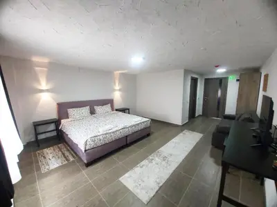 a bedroom with a bed and a living room at Vila Kruna in Belgrade