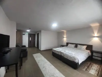 a bedroom with a bed and a couch and a desk at Vila Kruna in Belgrade