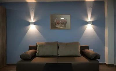 a living room with a couch and two lights on the wall at Vila Kruna in Belgrade