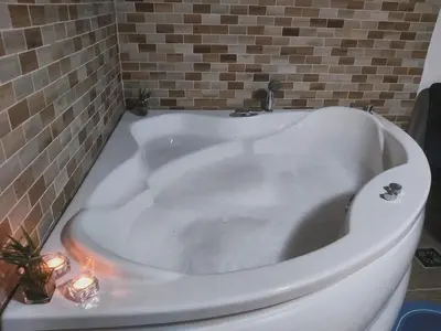 a white bath tub with candles in a bathroom at Vila Kruna in Belgrade