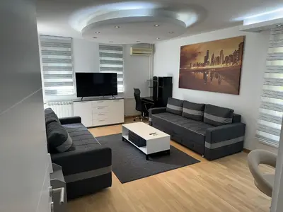 a living room with a couch and a tv at Apartman BK LUX in Belgrade