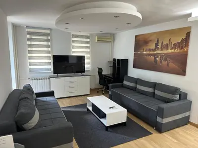 a living room with a couch and a tv at Apartman BK LUX in Belgrade