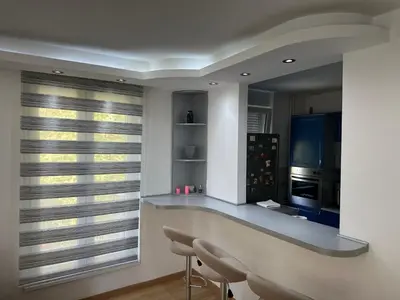 a kitchen with a counter with chairs and a window at Apartman BK LUX in Belgrade
