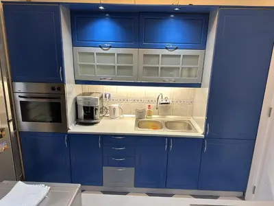 a blue kitchen with a sink and a microwave at Apartman BK LUX in Belgrade