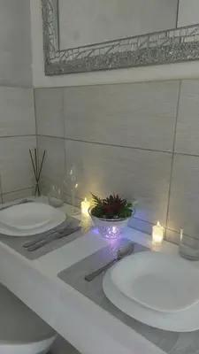 a bathroom with two sinks and two candles on a counter at Plavi Tirkiz in Pančevo