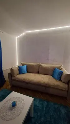 a living room with a brown couch with blue pillows at Plavi Tirkiz in Pančevo