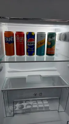 an open refrigerator with cans of drinks in it at Plavi Tirkiz in Pančevo