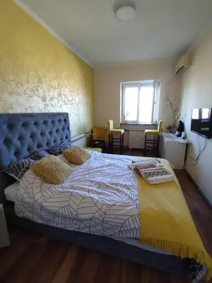 a bedroom with a large bed with a blue headboard at Sajam in Senjak (historical)