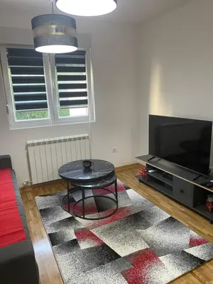 a living room with a coffee table and a flat screen tv at Apartman Fame near Airport in Surčin