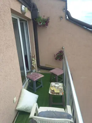 a balcony with a table and chairs on a building at Lux Apartman 7 in Voždovac