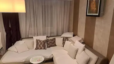 a living room with a white couch with pillows at Lux Apartman 7 in Voždovac