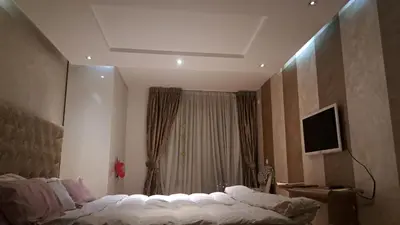 a bedroom with a bed and a television on a wall at Lux Apartman 7 in Voždovac