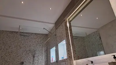 a bathroom with a shower and a large mirror at Lux Apartman 7 in Voždovac