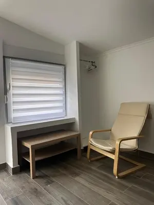a room with a chair and a table and a window at MELIORA Apartment in Belgrade