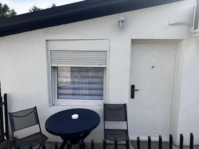 a table and chairs in front of a house with a door at MELIORA Apartment in Belgrade