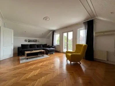 a living room with a black couch and a yellow chair at Plavi Dunav in Stari Slankamen