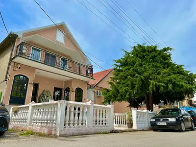 a house with a white fence and a car parked in front at Plavi Dunav in Stari Slankamen