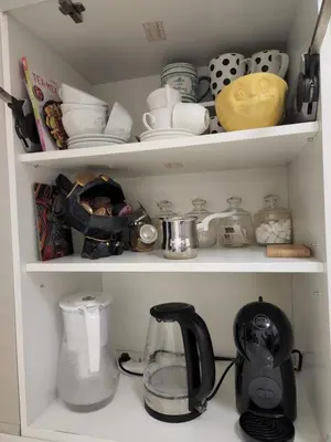 a cupboard filled with lots of kitchen items at AirCity Apartment in Belgrade