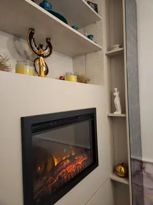 a fireplace in a living room with a fire at AirCity Apartment in Belgrade