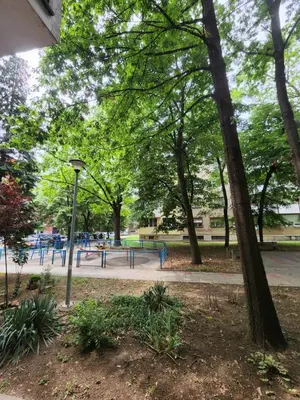 a park with a playground with trees and a light pole at AirCity Apartment in Belgrade