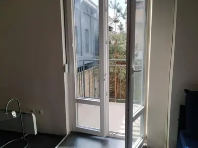 an open glass door with a view of a balcony at Flower Square Studio in Belgrade