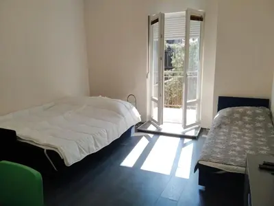 a white bedroom with a bed and a window at Flower Square Studio in Belgrade