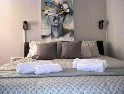 a bed with two pillows and a painting of a woman at 89 rooms in Belgrade