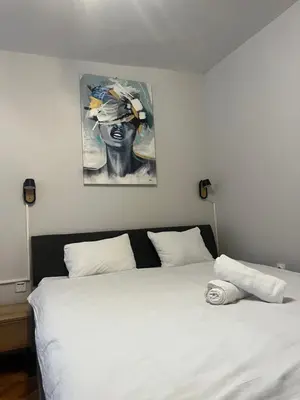 a bedroom with a white bed with a painting on the wall at 89 rooms in Belgrade