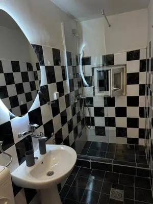 a bathroom with a sink and black and white checkered tiles at 89 rooms in Belgrade