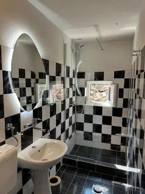a bathroom with a black and white checkered wall at 89 rooms in Belgrade